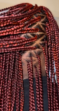 the back of a woman's hair with red braids