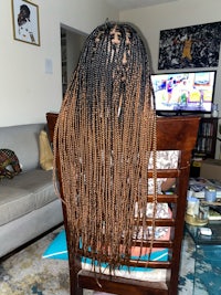 a woman sitting in a chair with long braids